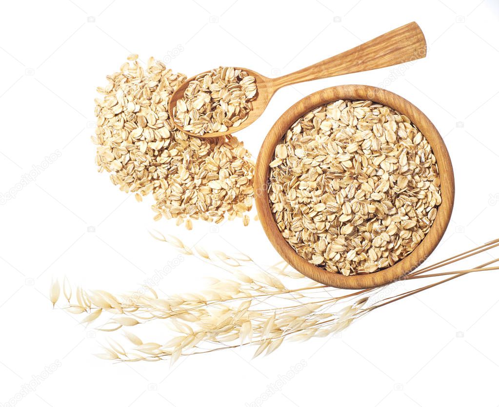 Oat flakes uncooked  in  wooden  bowl on white background concept of healthy eating vegan food
