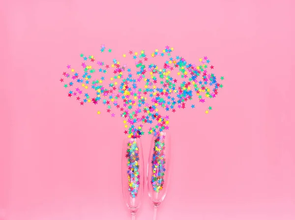 ピンクの背景にカラフルな紙吹雪と つのシャンパン グラス トップ ビュー — ストック写真