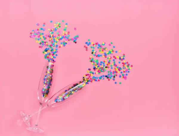 ピンクの背景にカラフルな紙吹雪と つのシャンパン グラス トップ ビュー — ストック写真