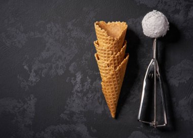 Vanilyalı dondurma için waffle konileri ve küçük bir kaşık bekleyen f