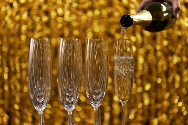 Versare champagne in bicchieri su sfondo chiaro — Foto Stock