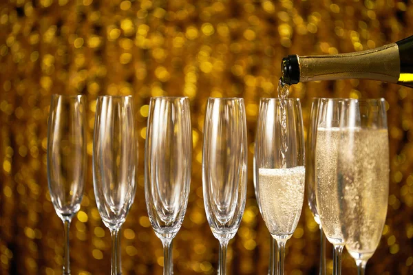 Pouring champagne into glass  on a light background, — Stock Photo, Image