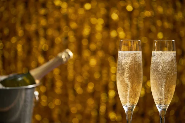 Two glasses of champagne on golden bokeh background — Stock Photo, Image