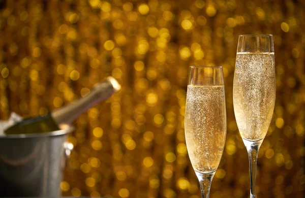 Due bicchieri di champagne su sfondo bokeh dorato, concetto di celebrazione delle vacanze , — Foto Stock