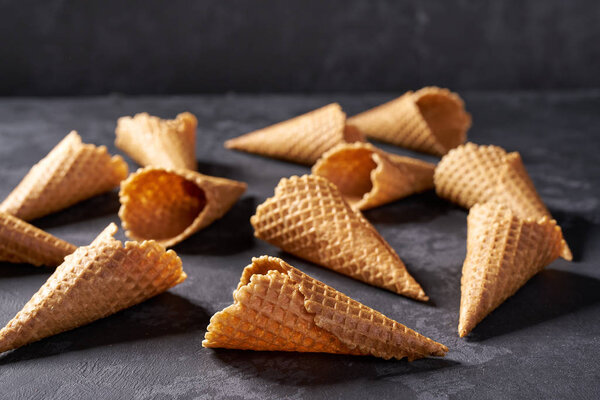 Sweet waffle cones for ice cream  on black background, horizontal composition