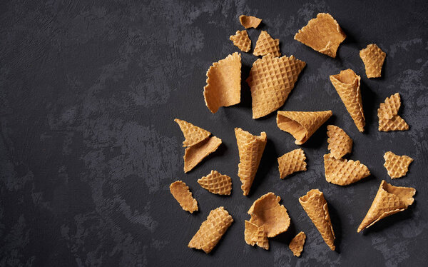 Раздавленные вафельные рожки на черном фоне
.