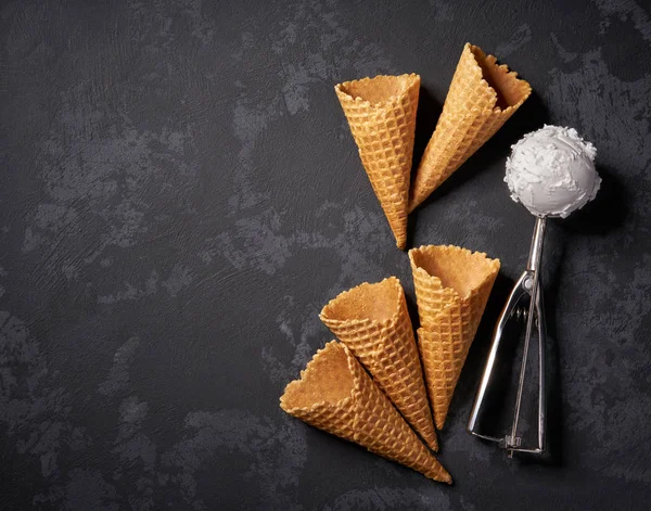 Cones de waffle de sorvete e uma colher para ele em backgroun preto — Fotografia de Stock