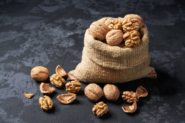 Siyah masa üzerinde çanta doğal ceviz. Ceviz yığını veya yığını.