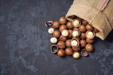 Kopya alanı ile siyah arka plan üzerinde çanta macadamia fındık. Üstte görüntü.
