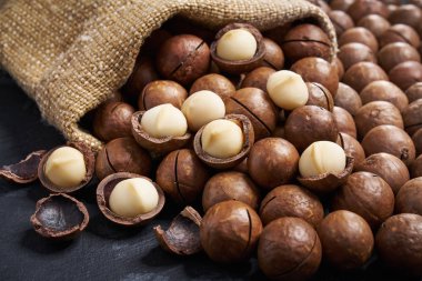 Siyah masa üzerinde çuval içinde Macadamia fındık. Close.