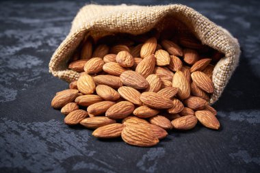 Siyah bir masaüzerinde çantadan badem dökülür,Yakın çekim