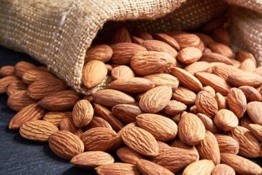 Siyah masa üzerinde çuval içinde Badem.