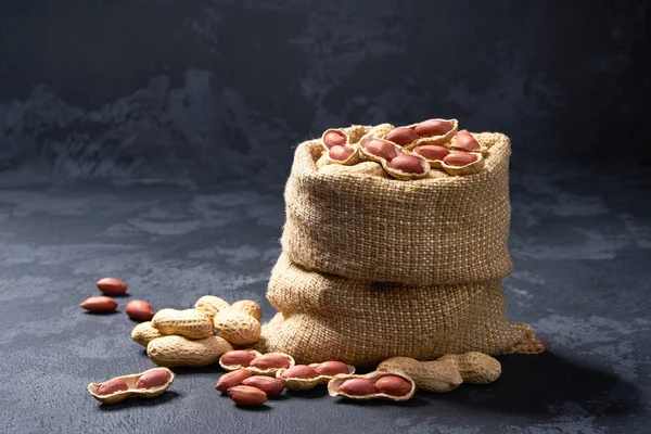 Arachides en sac sur table noire. tas ou pile de cacahuètes  . — Photo