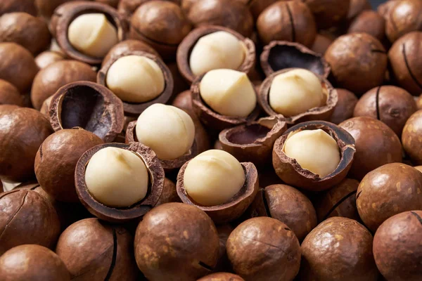 Noci di macadamia sgusciate e sgusciate sfondo primo piano . — Foto Stock