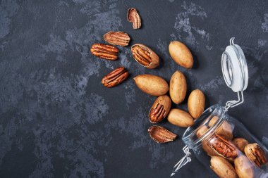 Siyah masa üzerinde açık bir cam kavanozda Pekan , yakın çekim. Üstte görüntü.