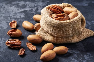 Siyah masa üzerinde çanta içinde Pecan. Yığın veya ceviz yığını.