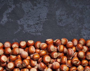 Siyah masa üzerinde kabuksuz fındık, kopya alanı ile. Üstte görüntü.