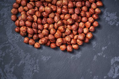 Siyah masa üzerinde kabuklu fındık, kopya alanı ile. Üstte görüntü.