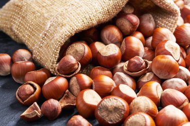 Siyah taş arka plan üzerinde çanta antep fıstığı. Yığın veya ceviz yığını.