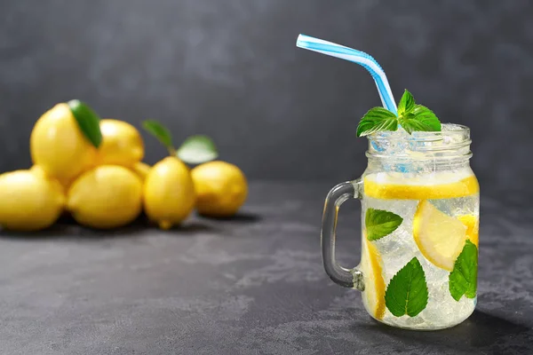 Frisch zubereitete Limonade in Gläsern auf schwarzem Hintergrund, kaltes Erfrischungsgetränk. gesundes und entgiftendes Wasser trinken. — Stockfoto