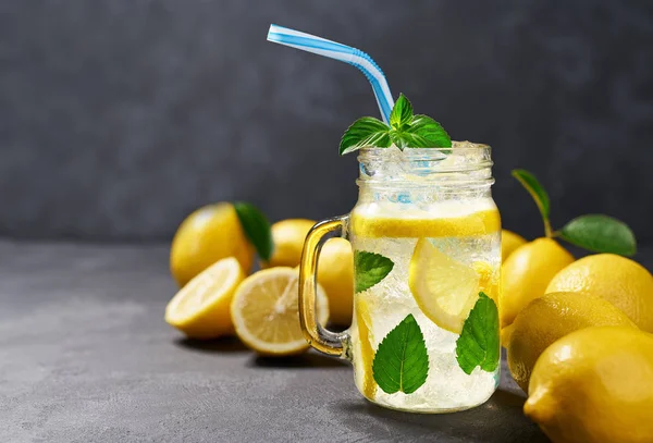 Frisch zubereitete Limonade in Gläsern auf schwarzem Hintergrund, kaltes Erfrischungsgetränk. gesundes und entgiftendes Wasser trinken. — Stockfoto