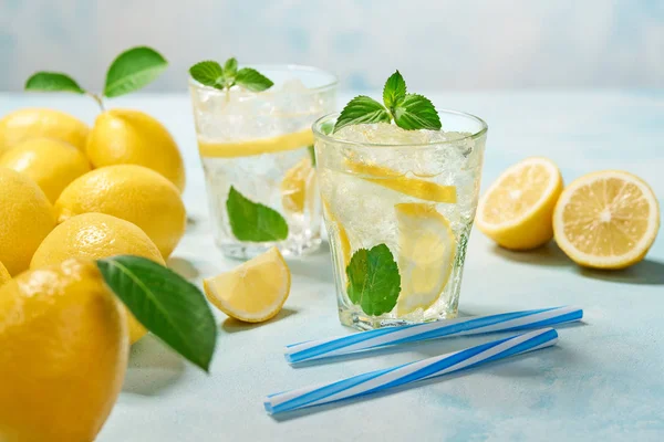 Dos vasos de limonada con limón fresco sobre fondo turquesa —  Fotos de Stock