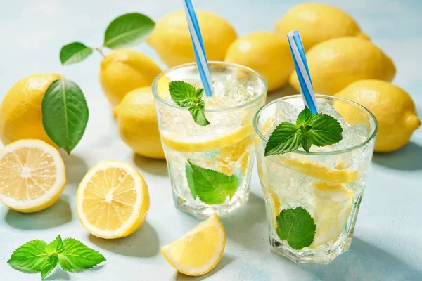 Dos vasos de limonada con limón fresco sobre fondo turquesa. Vista superior —  Fotos de Stock
