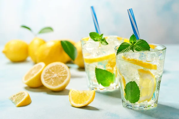 Dos vasos de limonada con limón fresco sobre fondo turquesa — Foto de Stock