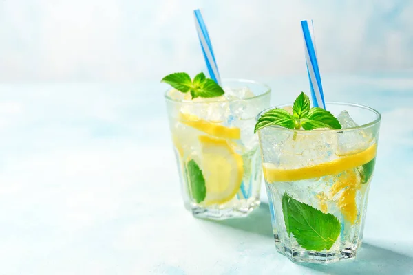 Dos vasos de limonada con limón fresco sobre fondo turquesa, con espacio para copiar —  Fotos de Stock