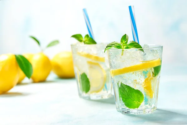 Dos vasos de limonada con limón fresco sobre fondo turquesa —  Fotos de Stock