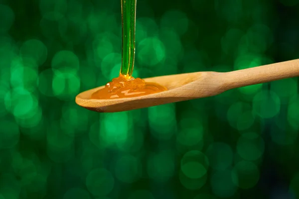 Miel Cae Sobre Una Cuchara Madera Sobre Fondo Verde Natural — Foto de Stock