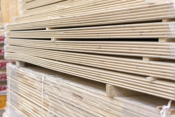 Packed boards in the building store. dry flat boards stacked together. close-up. building materials.