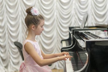 üzerinde siyah bir grand piyano güzel pembe elbiseli kız.