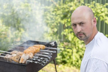 Genç çift kendi bahçesinde barbekü yapma. Barbekü üzerinde pişirme et dostum.