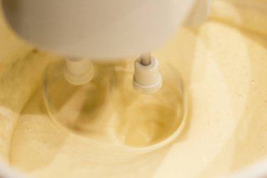 Şeker modern bir mutfak ile Mutfak Mikser sarı yumurta sarısı ile karışık. Mikser çırpma teli ile bir açıda açıkça görünür vurdu.
