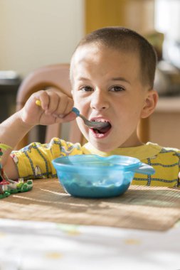 Çocuk 4 yıl püresi yiyor. Çocuk tablo. Çocuğun bağımsızlık kavramı. Çocuk bir iştahla mutfak arka planda breakfasting.