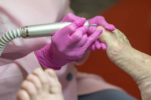 Kadın ayakları pedikür alma. Kavram kapatın. Özel elektrikli cihaz peeling feet. Ayak tedavi Spa salonda. Podiatry Kliniği