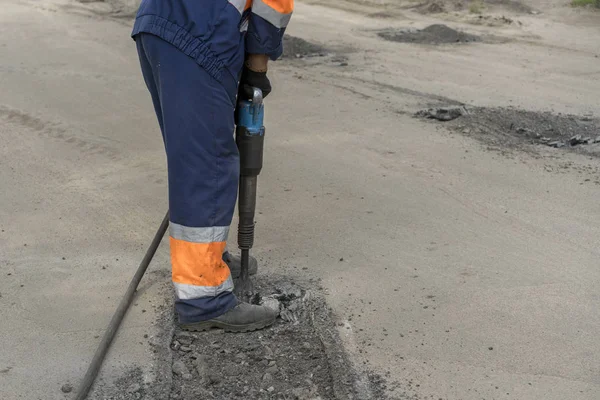 repair of roads. the worker is repairing the road.
