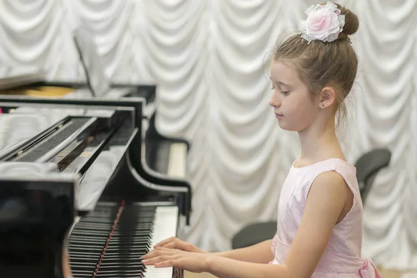 Девушка Красивом Розовом Платье Играет Черном Рояле — стоковое фото