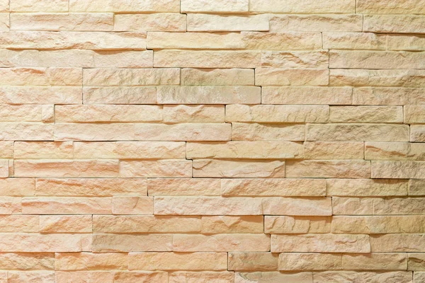 Wall made of decorative light brown stone. Decorating for the fireplace. Background.