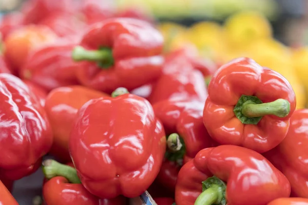 ed pepper on street market shelf. Red bell pepper pattern. Background of fresh sweet heap of red pepper paprica closeup vegetable shop. Red bulgarian paprika harvest pile from organic farm for sale.