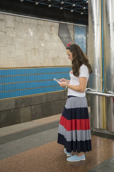 Egy Gyönyörű Várja Metró Egy Okostelefon Platformon Hosszú Haj — Stock Fotó