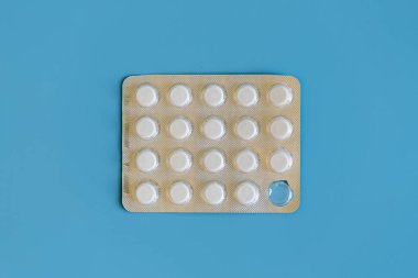 Beyaz hap mavi bir arka plan üzerinde. Bir tablet Vakumlu ambalaj eksik.