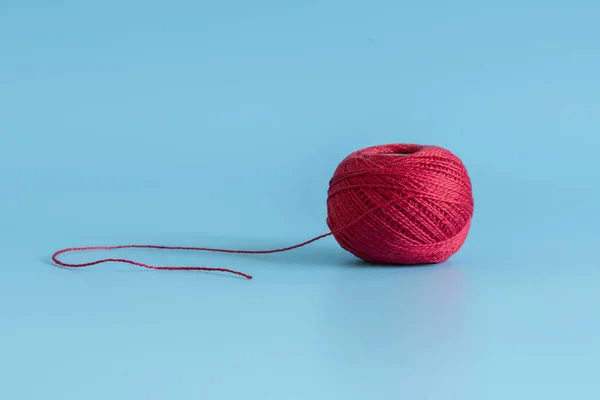 Red tangle of thread on a blue background.