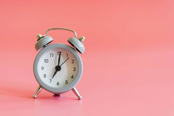 çalar saat pembe bir arka plan üzerinde. Vintage tarzı çalar saat ile kopya alanı metin için