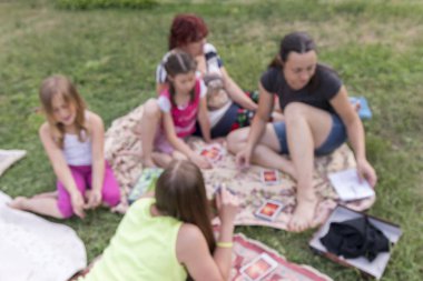 Oyun oynamayı çayır ailesinde. Eğitsel Oyunlar glade üzerinde oturan çocuklar oynar. Kamp. bulanık