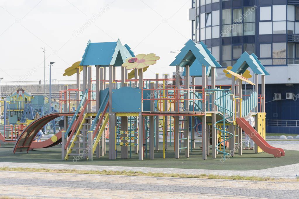 Modern children's playground near high-rise buildings.
