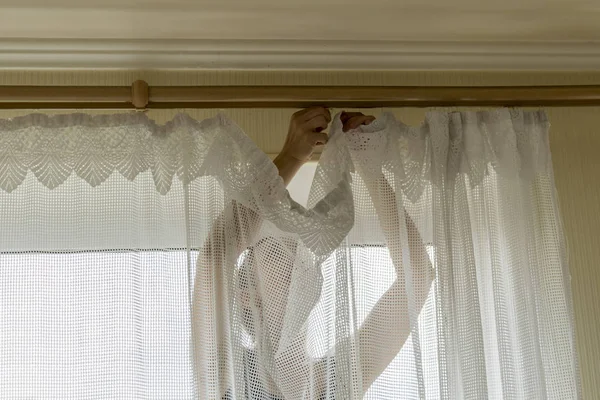 Perdelerin pencerelerde asılı kadın