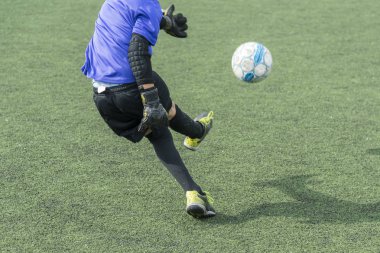 Futbol Stadı'nda oynayan çocuk. Oğlan topa vuruyor.