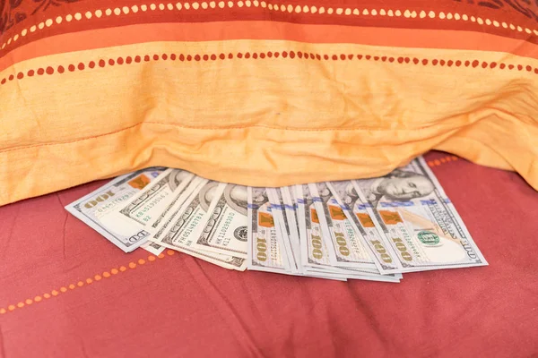 Hidden money under pillow close up. The concept of money accumulation
